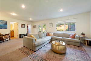 Carpeted living area with recessed lighting