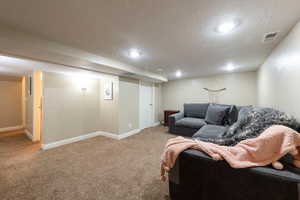 Living room with a textured ceiling and light carpet