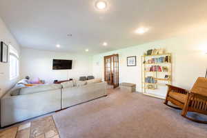 Living area with carpet flooring, recessed lighting, and french doors