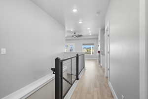 Corridor featuring an upstairs landing, recessed lighting, and light wood-type flooring