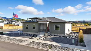 View of front of home with roof with shingles, a mountain view, and board and batten siding