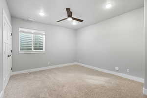 Unfurnished room featuring light colored carpet and ceiling fan