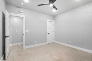 Spare room with light carpet and a ceiling fan