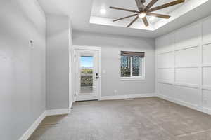 Spare room with a raised ceiling, carpet floors, a ceiling fan, and recessed lighting