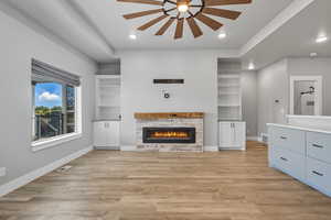 Unfurnished living room with a stone fireplace, light wood-type flooring, recessed lighting, and ceiling fan