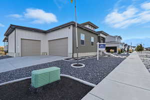 View of front of house with a mountain view, concrete driveway, and an attached garage