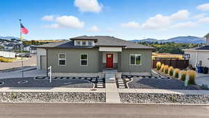 View of front of home featuring roof with shingles, a mountain view, board and batten siding, and driveway