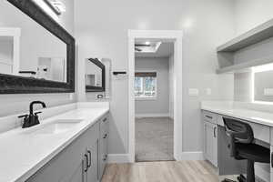 Full bath with light wood-style floors and two vanities