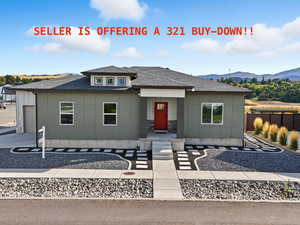 View of front facade featuring roof with shingles and board and batten siding