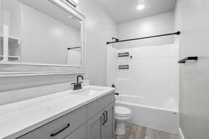 Bathroom with vanity, shower / bathtub combination, and light wood-style flooring