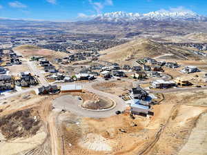 Aerial view of property and surrounding area featuring mountains and nearby suburban area