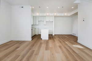 Kitchen with open floor plan, light countertops, a center island, white cabinetry, and recessed lighting