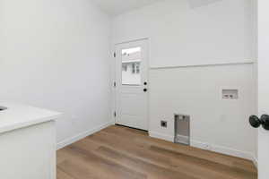 Laundry area with light wood-type flooring, hookup for a washing machine, and hookup for an electric dryer
