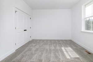 Unfurnished bedroom with carpet flooring and a closet