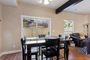 Dining space featuring wood finished floors, beam ceiling, and a chandelier