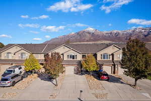 Traditional home featuring a mountain view, concrete driveway, and an attached garage