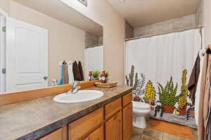 Bathroom featuring vanity, light tile patterned floors, and a shower with shower curtain