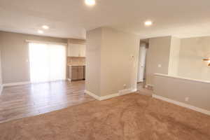 Empty room featuring light carpet, recessed lighting, and light wood-type flooring