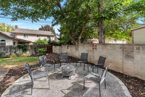 Fenced backyard featuring a patio and a fire pit