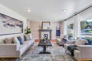 Living room featuring wooden walls, wood finished floors, recessed lighting, and a fireplace