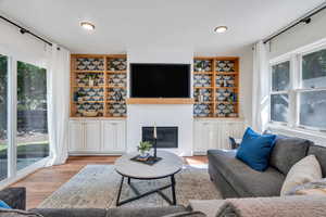 Living area featuring a fireplace, wood finished floors, and recessed lighting