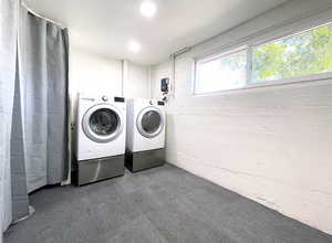 Laundry area featuring separate washer and dryer, dark carpet, wood walls, and recessed lighting