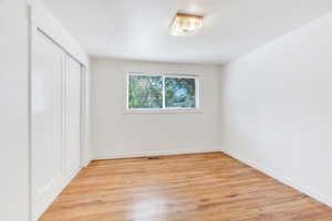 Unfurnished bedroom with light wood-style flooring and a closet