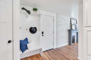 Entryway featuring wooden walls, light wood finished floors, and a fireplace