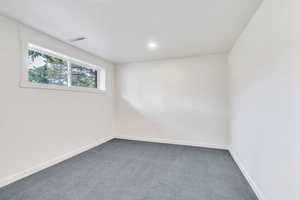 Empty room with carpet flooring and recessed lighting