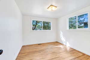 Spare room featuring light wood finished floors and baseboards