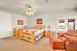 Bedroom with access to outside, light carpet, and a ceiling fan