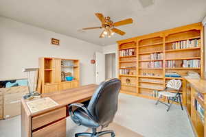 Office area with light carpet and a ceiling fan