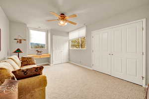 Living area with carpet flooring and a ceiling fan