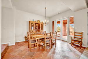 Dining room featuring stone tile floors and a chandelier