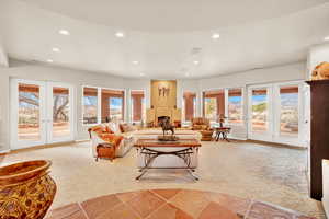 Carpeted living room featuring recessed lighting and french doors
