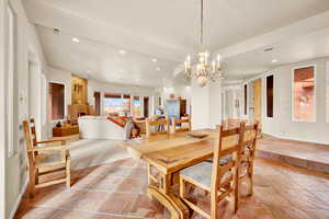 Dining area featuring recessed lighting, arched walkways, and stone tile flooring
