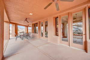 View of patio / terrace with a ceiling fan, french doors, outdoor dining area, and a mountain view