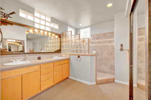Full bathroom with walk in shower, double vanity, recessed lighting, and light colored carpet