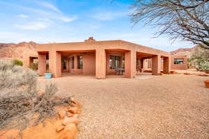 Back of property featuring a ceiling fan, stucco siding, a patio area, and a mountain view