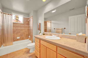 Bathroom with shower / bath combo with shower curtain, vanity, light tile patterned flooring, and recessed lighting