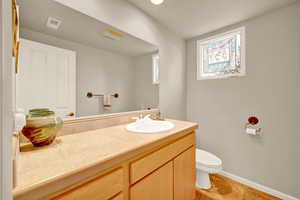 Half bathroom with vanity and light tile patterned flooring