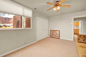 Unfurnished room featuring light carpet and ceiling fan