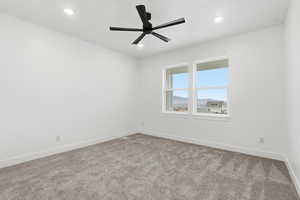 Empty room with carpet flooring, ceiling fan, recessed lighting, and a mountain view