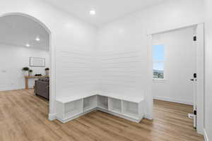 Mudroom featuring light wood-style floors, recessed lighting, and arched walkways