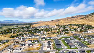 Aerial view of property and surrounding area with nearby suburban area and a mountain backdrop