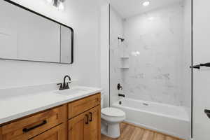 Bathroom featuring vanity, light wood-type flooring, and shower / bath combination