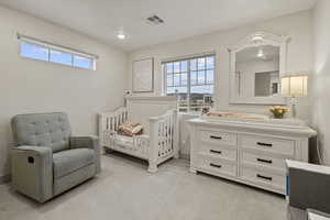 Bedroom with light colored carpet and recessed lighting