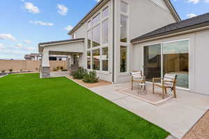 Rear view of property featuring stucco siding, a patio area, and ceiling fan
