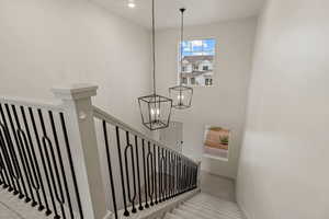 Stairway with carpet, a chandelier, and a towering ceiling