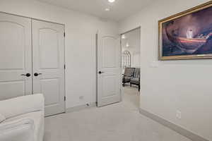 Sitting room with light colored carpet and recessed lighting